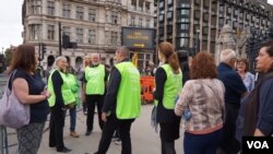 英國國會外站着一些穿着“撒瑪利亞會”(Samaritans)綠色背心的義工，讓傷心的民眾可以傾訴。（攝影：美國之音鄭樂捷）