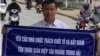 Nhà báo độc lập Lê Anh Hùng cầm tấm biển tố cáo ông Hoàng Trung Hải, cựu phó thủ tướng kiêm bộ trưởng Công nghiệp, trước khi bị bắt và kết án 5 năm tù.
