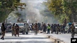 Taliban fighters stand guard at the site of an explosion, near a mosque, in Kabul, Afghanistan, Sept. 23, 2022. 