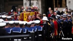 The coffin of Queen Elizabeth II is placed on a gun carriage during her funeral service in Westminster Abbey in central London Monday Sept. 19, 2022.

