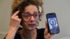 FILE - Iranian dissident and VOA Persian television host Masih Alinejad hold up a photo of an Iranian woman who was killed during the current protests in Iran, as she speaks during an interview with The Associated Press, in New York, Sept. 23, 2022.