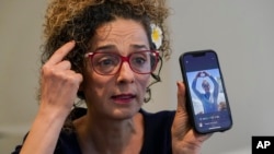 La disidente iraní Masih Alinejad sostiene una foto de una mujer iraní que fue asesinada durante la ola de protestas de 2022 en Irán mientras ofrece una entrevista con The Associated Press, el viernes 23 de septiembre de 2022, en Nueva York.