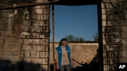 Alina Orobchenko stands at the door of her house that was destroyed after a Russian attack last month in Prudyanka village, Ukraine, Sept. 18, 2022. "It's really hard to decide what to do next," she says. "It's impossible to plan for the future."