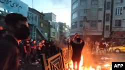 21일 이란 수도 테헤란 시내에서 마흐사 아미니 씨 사망에 항의하는 시위대가 집기에 불을 붙이고 있다. 