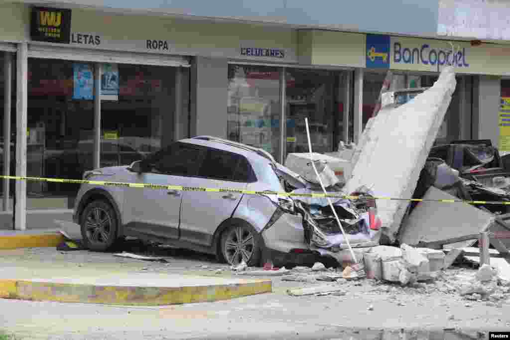 Vehicles damaged by the collapse of the facade of a department store during an earthquake are pictured in Manzanillo, Mexico, Sept. 19, 2022.