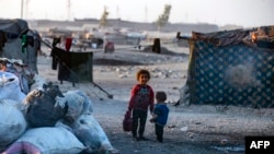 شام میں ہیضے کی وبا کےدوران رقہ میں بے گھر لوگوں کے ایک کیمپ میں ایک شامی لڑکی پانی کا ایک کنٹینر اٹھا کر لا رہی ہے۔ فوٹو اے ایف پی 19 ستمبر 2022۔