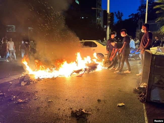 FILE - A police motorcycle burns during a protest over the death of Mahsa Amini, a woman who died after being arrested by the Islamic republic's morality police in Tehran, Iran, Sept. 19, 2022. (West Asia News Agency via Reuters)