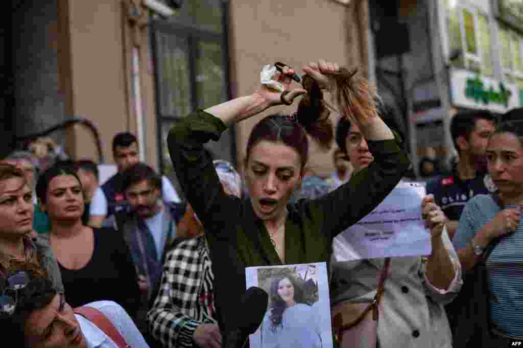 Nasibe Samsaei, an Iranian woman living in Turkey, cuts her ponytail off during a protest outside the Iranian Consulate in Istanbul, Sept. 21, 2022, following the death of an Iranian woman after her arrest by the country's morality police in Tehran.