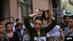 Nasibe Samsaei, an Iranian woman living in Turkey, cuts her ponytail off during a protest outside the Iranian Consulate in Istanbul, Sept. 21, 2022, following the death of an Iranian woman after her arrest by the country's morality police in Tehran.