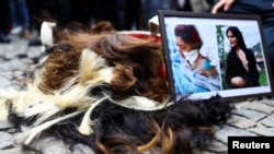 تظاهرکنندگان زن در اعتراض به مرگ مهسا امینی موی سر خود را بریده‌اند. برلین، آلمان. ٢٣ سپتامبر ٢٠٢٢