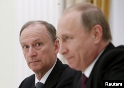 资料照：帕特鲁舍夫在一个会议上注视着讲话的普京总统。（2015年5月26日）