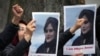 流亡伊朗人举着在伊朗警察局死亡的女子阿米尼的照片在伊朗驻柏林大使馆外抗议。（2022年9月20日）