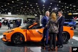 President Joe Biden talks with Mary Barra, CEO of General Motors, center, and an unidentified man, during a tour of the Detroit Auto Show, Sept. 14, 2022, in Detroit.