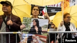 Demonstrant u New Yorku drži sliku Mahse Aminija, koja je umrla u policijskom pritvoru u Iranu, 22. septembra 2022.