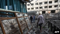 18일 우크라이나 동부 도네츠크 주 크라마토르스크에서 파괴된 건물들 사이로 주민들이 이동하고 있다. 