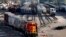 FILE- A BNSF rail terminal worker monitors the departure of a freight train, in Galesburg, Ill., June 15, 2021.