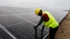 FILE - A technician works on solar power panels at the Atlantic Shrimpers farm in Badagry, Lagos, Nigeria, July 5, 2022. 