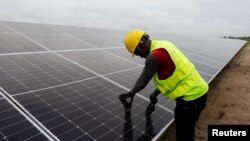 FILE - A technician works on solar power panels at the Atlantic Shrimpers farm in Badagry, Lagos, Nigeria, July 5, 2022. 