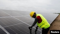 FILE - A technician works on solar power panels at the Atlantic Shrimpers farm in Badagry, Lagos, Nigeria, July 5, 2022. 