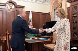 FILE - Russian President Vladimir Putin meets with Commissioner for Children's Rights Maria Lvova-Belova at the Kremlin in Moscow, March 9, 2022.