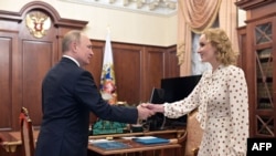 FILE - Russian President Vladimir Putin meets with Commissioner for Children's Rights Maria Lvova-Belova at the Kremlin in Moscow, March 9, 2022.