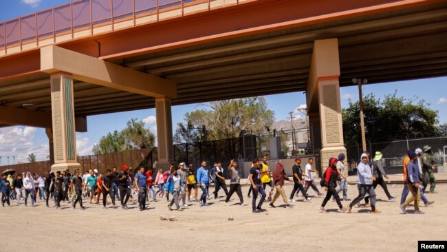 Migrantes, en su mayoría de Venezuela, caminan después de ser detenidos por agentes de la Patrulla Fronteriza de EE.UU. después de cruzar a Estados Unidos desde México para entregarse a solicitar asilo, en El Paso, Texas, EE.UU., 14 de septiembre de 2022. REUTERS/José Luis González