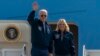 U.S. President Joe Biden waves as first lady Jill Biden watches standing at the top of the steps of Air Force One before boarding at Andrews Air Force Base, Md., Sept. 17, 2022. 