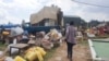 Une femme marche entre les biens des personnes qui sont expulsées dans le bidonville de Kangondo à Kigali au Rwanda, le 16 septembre 2022. (Photo AFP)