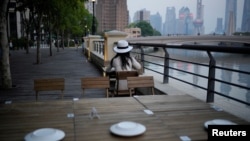 A woman sits in a restaurant on a river bank, following the coronavirus disease (COVID-19) outbreak, in Shanghai, China, September 6, 2022. (REUTERS/Aly Song)
