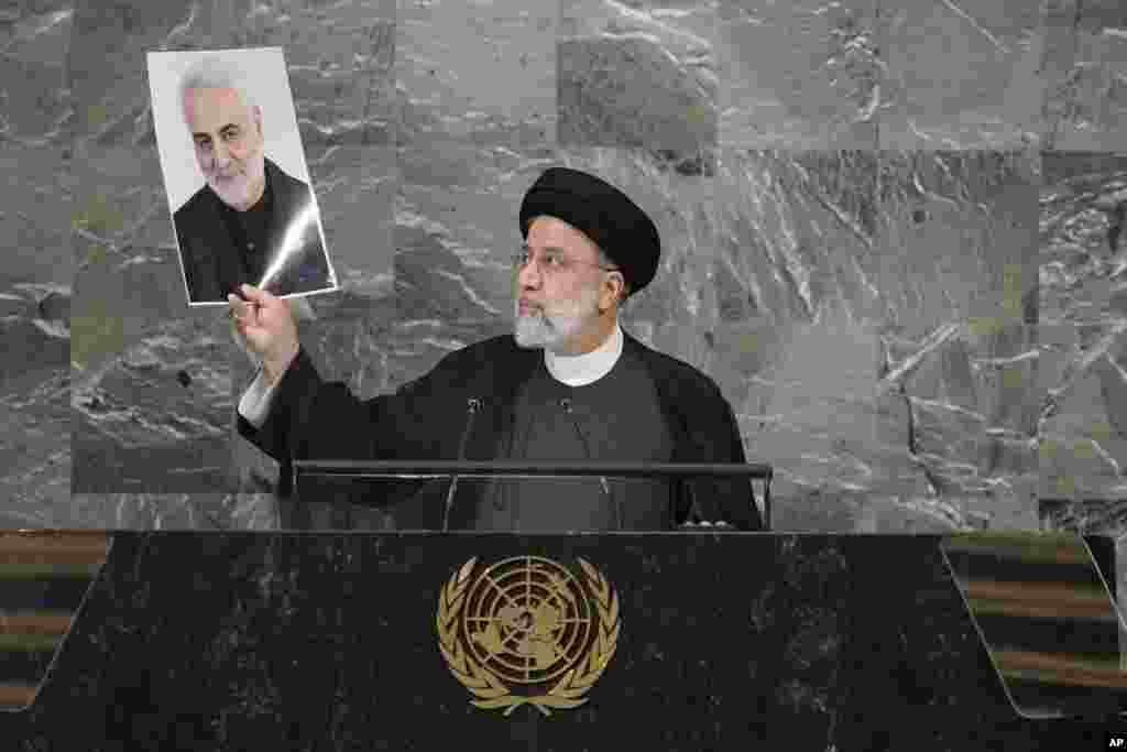 Presiden Iran Ebrahim Raisi mengangkat foto Jenderal Iran Qassem Soleimani yang terbunuh oleh serangan drone pasukan AS di Baghdad pada 9 Juli 2020, saat ia berpidato di sesi ke-77 Majelis Umum PBB di markas besar PBB di New York.