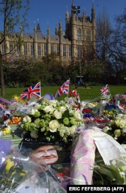 Terlihat foto ibu suri, ibunda Ratu Elizabeth II, di Westminster Hall di mana peti mati Ibu Suri disemayamkan di London 06 April 2002. (Foto: AFP/ERIC FEFERBERG)