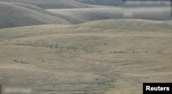 A still image from video, released by the Armenian Defence Ministry, shows what it said to be Azerbaijani service members moving along an unidentified mountainous border area with Armenia, in this still image taken from handout footage released Sept. 13, 2022.