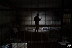 An Ukrainian serviceman stands in a basement which, according to Ukrainian authorities, was used as a torture cell during the Russian occupation, in the retaken village of Kozacha Lopan, Sept. 17, 2022.