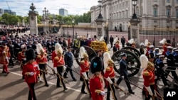 The coffin of Queen Elizabeth II with the Imperial State Crown resting on top, borne on the State Gun Carriage of the Royal Navy proceeds past Buckingham Palace in London, during the state funeral of Queen Elizabeth II, Monday Sept. 19, 2022. (Jenny Gooda