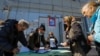 Local residents wait before receiving ballots from members of an electoral commission and casting their votes into a mobile ballot box on the third day of referendum, in Mariupol, Ukraine, Sept. 25, 2022. 