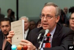 FILE - Independent counsel Kenneth Starr holds a copy of his report while testifying on Capitol Hill, Nov. 19, 1998, before the House Judiciary Committee's impeachment hearing during the Clinton presidency.