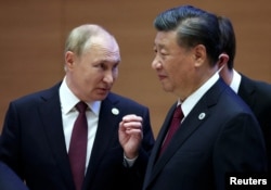 FILE - Russian President Vladimir Putin speaks with Chinese President Xi Jinping before an extended-format meeting of heads of the Shanghai Cooperation Organization summit (SCO) member states in Samarkand, Uzbekistan, Sept. 16, 2022. (Sputnik/Sergey Bobylev/Pool via Reuters)