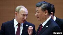 俄罗斯总统普京在乌兹别克斯坦撒马尔罕举行的上海合作组织峰会成员国首脑扩大会议前与中国国家主席习近平交谈。（2022年9月16日） 