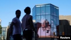 People walk by as a tribute to Queen Elizabeth appears on the National Arts Centre, after Queen Elizabeth's passing, in Ottawa, Ontario, Canada, September 8, 2022. REUTERS/Patrick Doyle