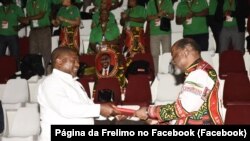 Joaquim Chissano, antigo Presidente da Frelimo (dir), entrega os símbolos do partido a Filipe Nyusi, reeleito presidente da Frelimo (esq)