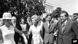 FILE - First lady Pat Nixon leads Princess Anne, as President Richard Nixon and Prince Charles walk with them, at the White House, July 16, 1970.