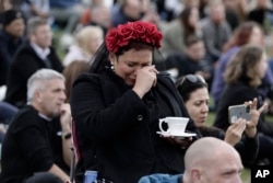 Seorang perempuan menangis di Hyde Park saat menonton Pemakaman Kenegaraan Ratu Elizabeth II Inggris di layar raksasa, Senin, 19 September 2022 di London. (Foto: AP/Lewis Joly)