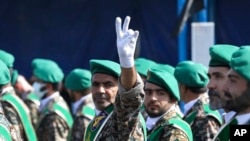 A member of Iran's Basij paramilitary force flashes a victory sign during a military parade just outside Tehran, Iran, Sept. 22, 2022.