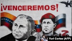 Caraqueños posan delante de un dibujo pintado por el muralista Zapatista y que muestra al presidente Putin y al expresidente Chávez.