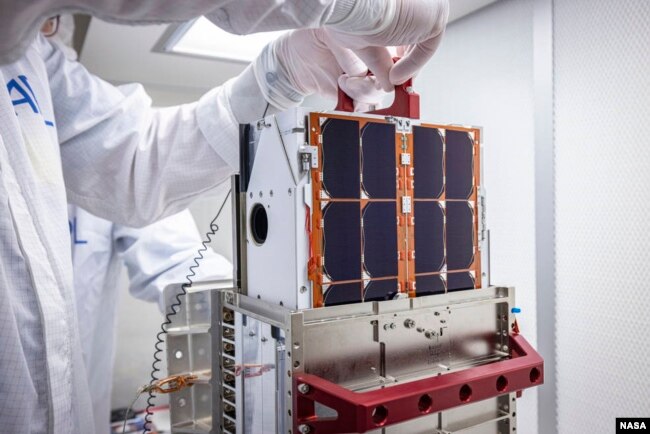 DART team engineers lift and inspect the LICIACube CubeSat after it arrived at the Johns Hopkins Applied Physics Laboratory (APL) in Laurel, Maryland in August. The miniaturized satellite will deploy 10 days before DART's asteroid strike. (Image Credits: NASA/Johns Hopkins APL/Ed Whitman)