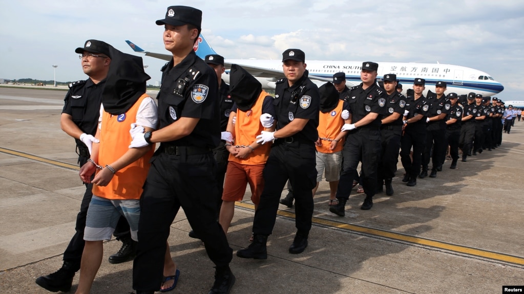 中国警察在长沙黄花国际机场押送一批从柬埔寨遣返的电信诈骗嫌疑人。（2017年7月6日）(photo:VOA)