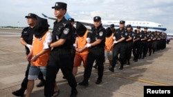 中国警察在长沙黄花国际机场押送一批从柬埔寨遣返的电信诈骗嫌疑人。（2017年7月6日）