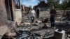 ILustrasi: Penduduk setempat berdiri di dekat amunisi mortir di jalan yang hancur di desa Kamyanka, wilayah Kharkiv, Ukraina yang baru-baru ini dibebaskan oleh Angkatan Bersenjata Ukraina, 22 September 2022. (REUTERS/Gleb Garanich)