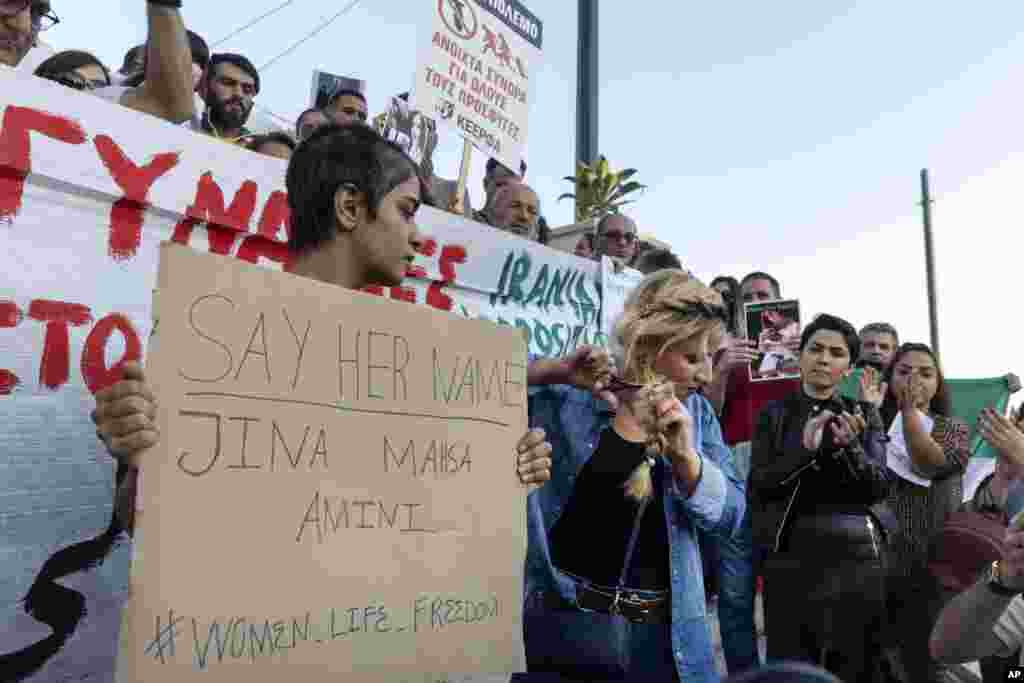 A woman cuts her hair during a protest against the death of Iranian Mahsa Amini, at central Syntagma square, in Athens, Greece, Sept. 24, 2022.