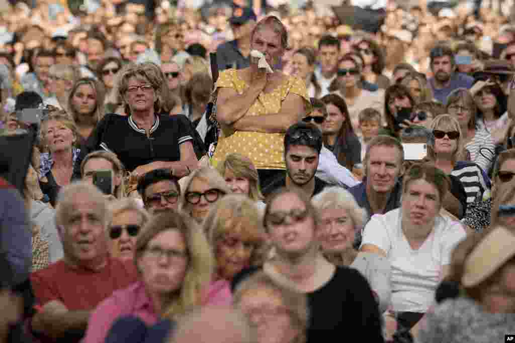 A woman weeps as she joins people gathered in Hyde Park, London, Sept. 14, 2022, to watch screens broadcasting the procession of the coffin of Queen Elizabeth II from Buckingham Palace to Westminster Hall.